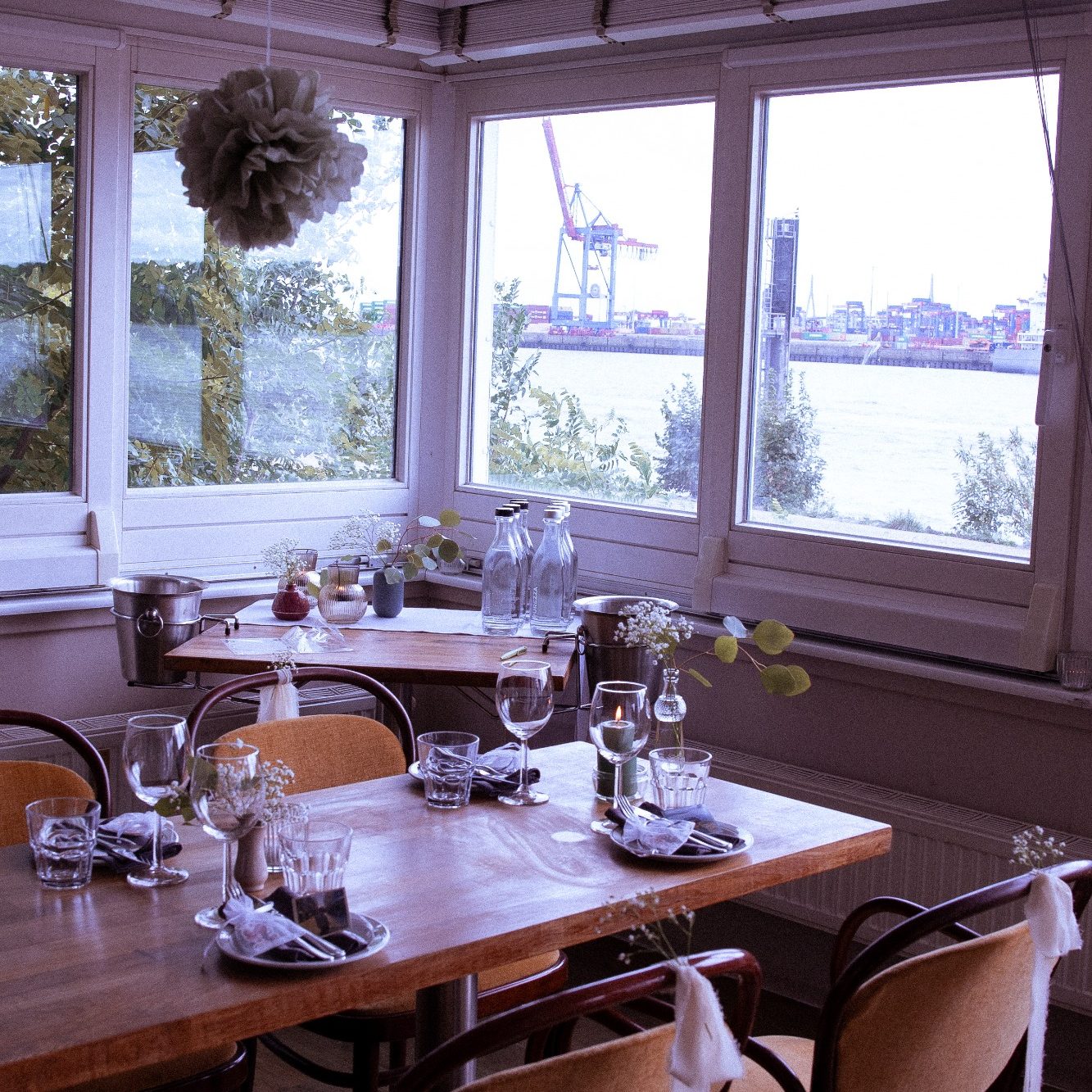 Hochzeit feiern im Illeta Mallorqui am Hamburger Elbstrand Festlich gedeckte Hochzeitstafel mit Blumen im Illeta Mallorqui und Blick auf die Elbe